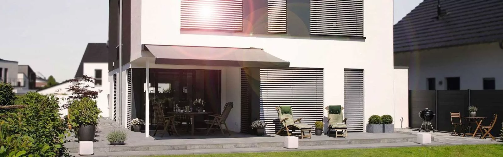 Markise und Rollladen an modernen weißen Haus