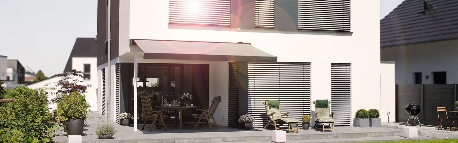 Terrassendach an modernen weißen Haus mit Garten